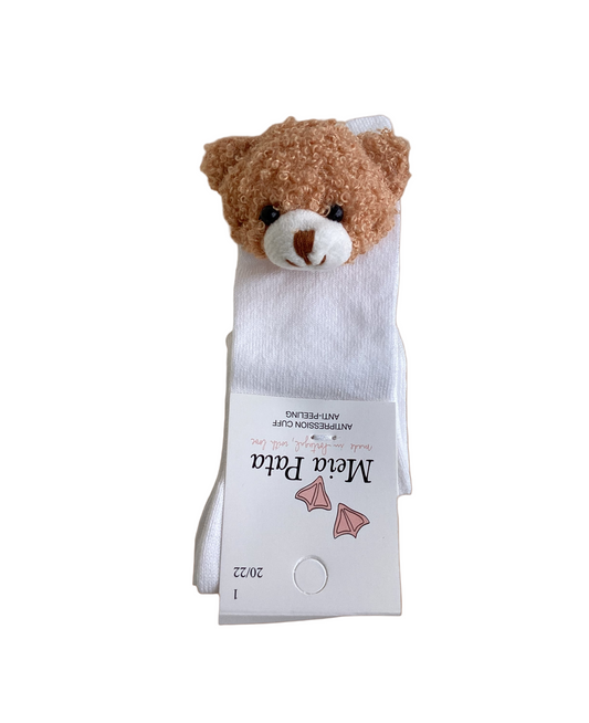 A white sock with a 3D plush teddy bear design on the cuff, set against a brown background.
