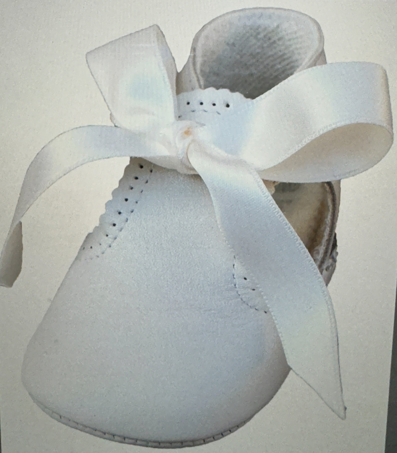 White&nbsp; pre-walker shoes for baby&nbsp; &nbsp;Trimmed with pretty Satin detailing, they fasten with organza bows on the front for an adorable look. Made in super soft leather with a sheen, they have a comfortable fabric lining and a cushioned sole for the baby's little feet.