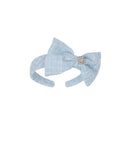 Light blue bow headband with a decorative element on a white background