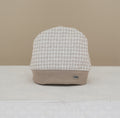 Soft brushed cotton houndstooth baby cap in beige &amp; cream. Matches Dino Collection outfits, hats, booties &amp; coats. Sizes 0–12M.